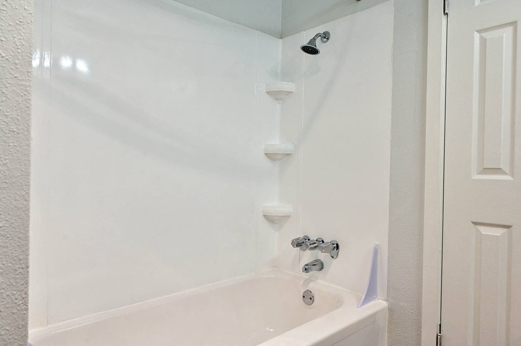 a white bathroom with a tub and a shower